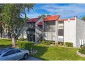 Condo building showcasing multiple units with red tile roofs and lush landscaping at 3245 Beneva Rd # 104, Sarasota, FL 34232