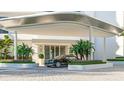 Modern building entrance with covered carport and landscaping at 555 Quay Cmn # 803, Sarasota, FL 34236