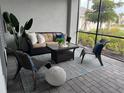 Outdoor patio with wicker furniture, a rug, and a view of lush greenery and landscaping at 17445 Opal Sand Dr # 104, Venice, FL 34293