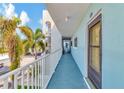 View of condo hallway with light blue walls and white railing at 12405 3Rd E St # 206, Treasure Island, FL 33706