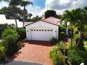 Property features brick driveway, white house, and lush landscaping at 2107 89Th St Nw, Bradenton, FL 34209