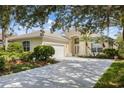 House exterior featuring a two-car garage and landscaping at 7335 Saint Georges Way, University Park, FL 34201