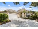 House exterior featuring a two-car garage and landscaping at 7335 Saint Georges Way, University Park, FL 34201