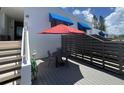 Private patio with table, chairs and red umbrella at 826 Bayport Way # 826, Longboat Key, FL 34228