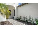 Home entryway featuring a brick pathway and manicured landscaping at 109 Corserra Dr, Nokomis, FL 34275