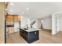 Modern kitchen with light wood cabinets, dark island, and quartz countertops at 12926 Pinnacle Ln, Venice, FL 34293