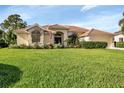 Well-maintained single-story home with a lush green lawn, featuring a tile roof and manicured landscaping at 13791 Palmetto Point Ct, Port Charlotte, FL 33953