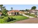 Attractive single-story home with a tile roof, an expansive green lawn, and well-maintained landscaping at 13791 Palmetto Point Ct, Port Charlotte, FL 33953