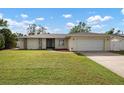 House exterior showcasing a large yard and a two-car garage at 6743 2Nd Avenue W Cir, Bradenton, FL 34209