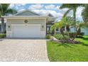 Single-story home with a two-car garage and landscaped yard at 10446 Coquina Ct, Placida, FL 33946