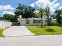 Ranch style home with carport, mature landscaping, and fenced yard at 2717 Grove Pl, Sarasota, FL 34239