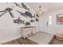 Coastal-themed entryway with decorative fish wall art and console table at 1200 Via Tripoli, Punta Gorda, FL 33950