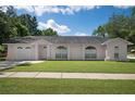 Pink one-story house with a two-car garage and manicured lawn at 2299 Hamlin Ct, Valrico, FL 33594