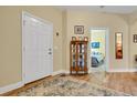 Entryway with hardwood floor, display cabinet, and view of bedroom at 1201 Bensbrooke Dr, Wesley Chapel, FL 33543