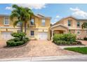 Front view of two-story townhouses with attached garages and landscaped yards at 7676 Bergamo Ave, Sarasota, FL 34238