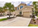 Three-story townhome with two-car garage, landscaping, and palm trees in front at 8269 Enclave Way # 103, Sarasota, FL 34243