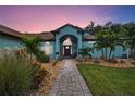 Inviting front entrance with landscaped walkway leading to a covered porch and stylish front door at 4888 Oak Pointe Way, Sarasota, FL 34233