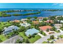 Aerial view of waterfront home community, showcasing houses with lush landscaping and a canal at 1768 S Creek Ln, Osprey, FL 34229