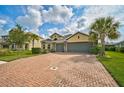 Brick driveway and a three-car garage of a two-story house at 5514 69Th E Pl, Ellenton, FL 34222