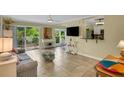 Bright living room with tiled floors and patio access at 3413 Clark Rd # 114, Sarasota, FL 34231