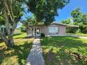 Single story house with carport, screened porch, and well-maintained lawn at 21154 Bersell Ave, Port Charlotte, FL 33952