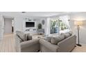 Bright living room with comfy sofas, large TV, and sliding glass doors leading to the backyard at 4108 101St W St, Bradenton, FL 34210