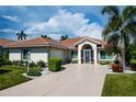 Single-story home with tile roof, landscaping, and driveway at 6772 Greenview Ln, Englewood, FL 34224