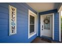 Inviting exterior with a blue facade, white door, and welcome sign at 213 75Th St, Holmes Beach, FL 34217