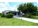 Ranch-style home with a screened porch and mature landscaping at 2434 Fourwind St, Port Charlotte, FL 33948