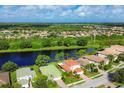 Aerial view of a community with houses and a lake at 11492 Dancing River Dr, Venice, FL 34292