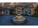 Elegant home entrance with fountain at night at 3218 Signet Ct, Sarasota, FL 34240
