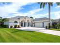 Beautiful single-story home with an attached three-car garage, a well-manicured lawn, and lovely landscaping at 15923 29Th E St, Parrish, FL 34219