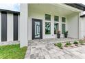 Modern entryway with a unique door and paver patio at 13457 Drysdale Ave, Port Charlotte, FL 33981