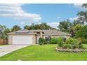 House with a white garage door, green lawn, and mature landscaping at 4288 Birnam Ter, North Port, FL 34286