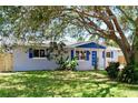 Newly renovated home with gray exterior, blue accents and landscaping at 430 Tanager Rd, Venice, FL 34293