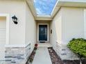 Inviting home entrance with a covered porch and decorative stone accents at 10827 Charlotte Dr, Parrish, FL 34219