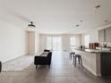 Open-concept living area with ceramic tile floors and a modern interior design at 10827 Charlotte Dr, Parrish, FL 34219