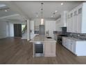 Spacious kitchen with white cabinets, marble countertops, and hardwood floors at 4819 Higel Rd, Sarasota, FL 34242