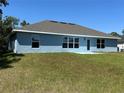 The backyard has a well-maintained lawn with a simple patio leading from a door on the house at 4865 Manila Ave, North Port, FL 34288