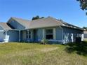 A side view of the light blue, one-story home with off white trim and a well-maintained lawn at 4865 Manila Ave, North Port, FL 34288