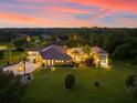 An estate property showcasing a large house, pool, and expansive grounds at dusk at 17812 Doe Creek Ct, Parrish, FL 34219