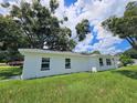 Side view of a newly painted house with a large tree in the front at 100 N Duncan Ave, Clearwater, FL 33755
