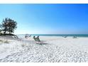 White sand beach with lounge chairs and ocean view at 19 Whispering Sands Dr # 204, Sarasota, FL 34242