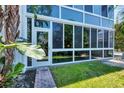 Bright, sunlit condo exterior with glass walls at 2100 Benjamin Franklin Dr # 105, Sarasota, FL 34236
