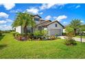 Beautiful home featuring a tropical landscape, healthy green lawn, and spacious driveway at 17006 Blue Ridge Pl, Lakewood Ranch, FL 34211