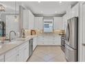 Modern kitchen boasts white cabinets, stainless steel appliances, and tile floors at 5732 Puccini St, Nokomis, FL 34275