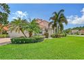 Single-story house with lush landscaping and palm trees at 5814 Fairwoods Cir, Sarasota, FL 34243