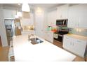Modern kitchen with white cabinets and island at 118 Veraza Ct, Nokomis, FL 34275