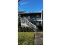 Front view of two-story condo with stairs and landscaping at 6033 34Th W St # 1, Bradenton, FL 34210