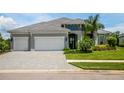 Two-story house with three-car garage and paver driveway at 12444 Destin Loop, Venice, FL 34293
